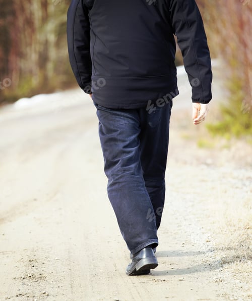 Preview: An Older Man Is Walking On The Road. He Is Walking Away. The Man Is Wearing Dark Jeans And A Black