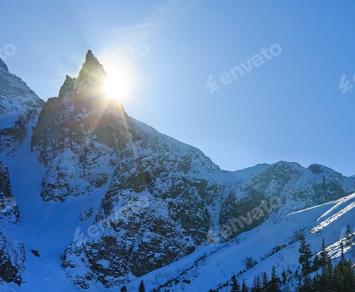 Preview: Winter Rocky Mountain View And Sun Peeks Out From Behind The Rocks.