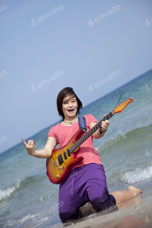 Preview: Young Brunet Girl With Guitar On The Beach.