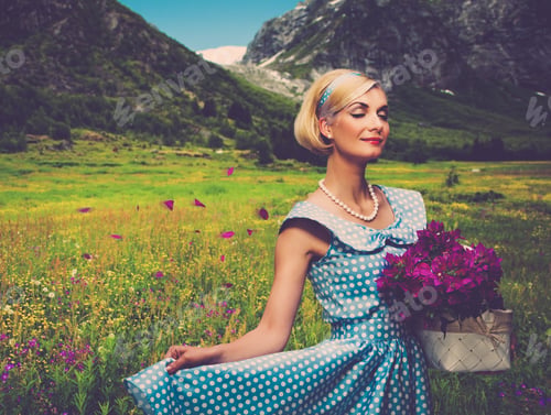 Preview: Lovely Woman In Blue Dress With Basket Of Flowers Against Mountain View