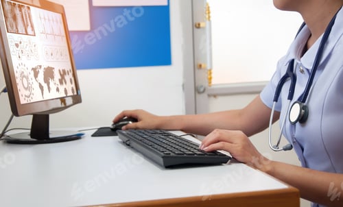 Preview: Doctor Working With Computer At Desk In The Hospital