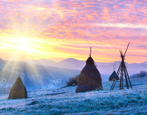 Preview: First Autumn Frosts On Pasture With Haystacks And Majestic Sunrise In The Mountains Village