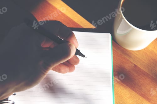 Preview: A Man Is Writing A Letter. A Cup Of Coffee Is Next To The Empty Notepad Page. Image Has A Vintage