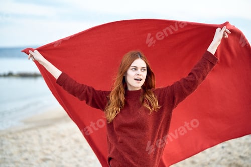 Preview: Woman On The Beach With A Red Scarf In Her Hands