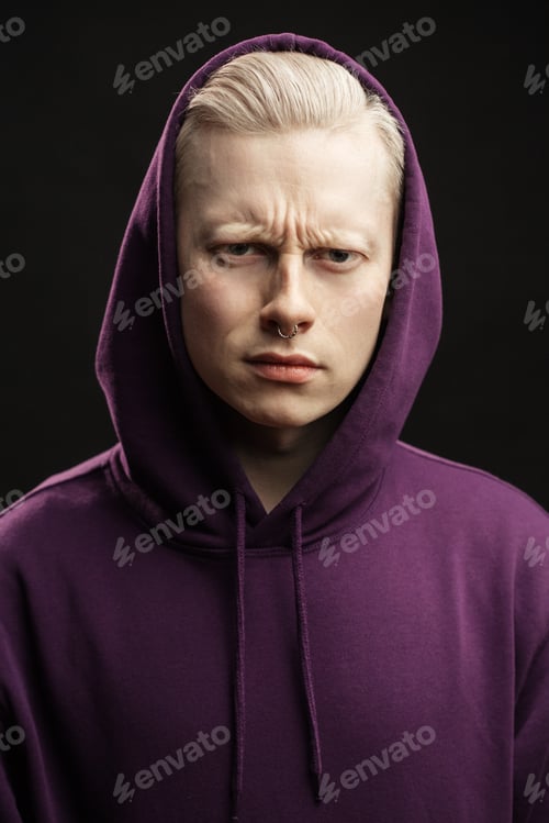 Preview: Blonde Displeased Guy In Purple Sweatshirt With A Hood Over His Head Frowning Brows Looking At