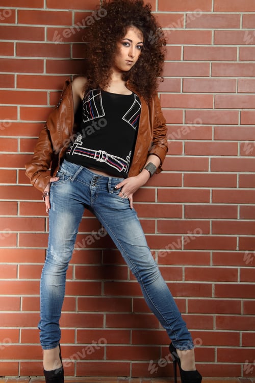 Preview: Beautiful Girl With Curly Hair On A Background A Brick Wall