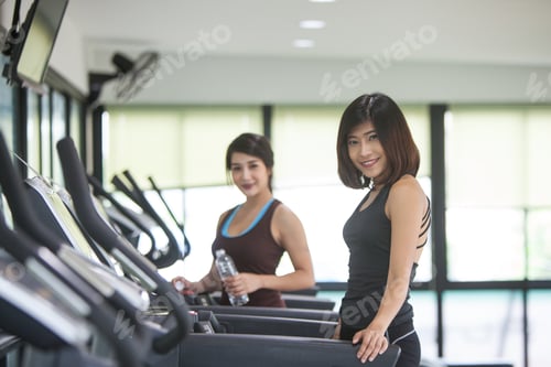 Preview: Two Smiling Sporty Young Women Posing On Treadmill