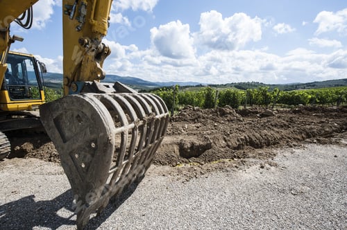 Preview: Excavator Bucket On The Asphalt Road Near The Vineyard. Excavator In Construction Site On The
