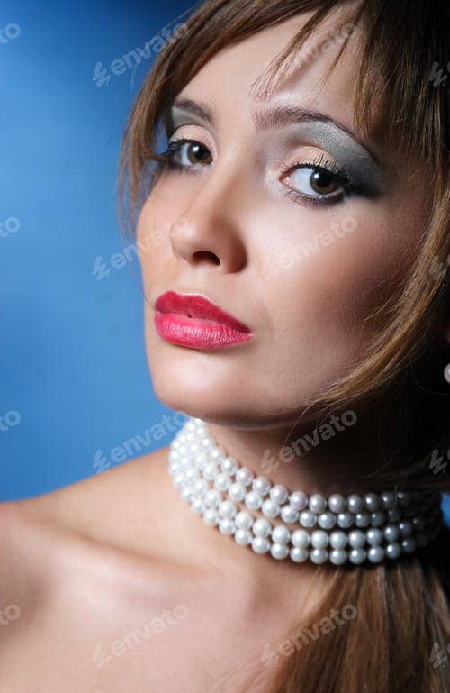 Preview: Portrait Of Beautiful Young Girl On A Blue Background With Pearls