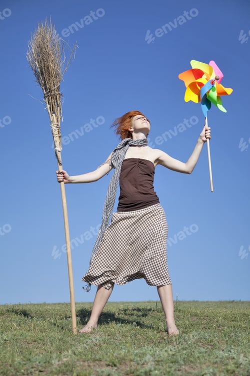 Preview: Young Witch At Green Field With Broom And Wind Turbine