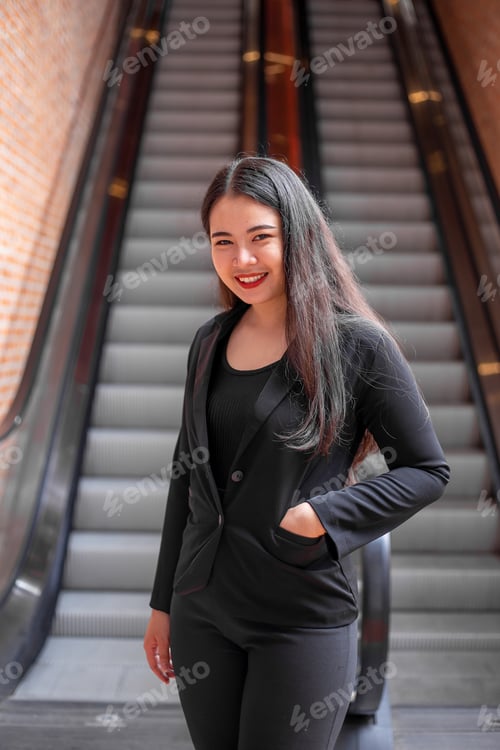 Preview: The Asian Woman Wearing The Black Uniform Standing In The Front Of Escalator With Brick Wall