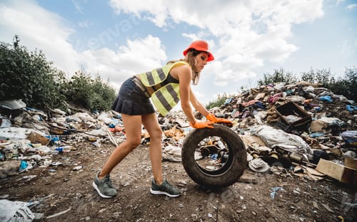 Preview: Woman Volunteer Helps Clean The Field Of Plastic Garbage And Old Tires. Bushes And Sky In The