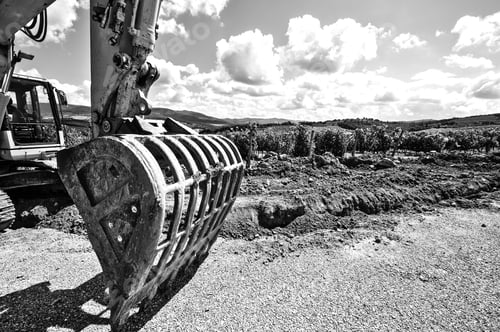 Preview: Excavator Bucket On The Asphalt Road Near The Vineyard. Excavator In Construction Site On The