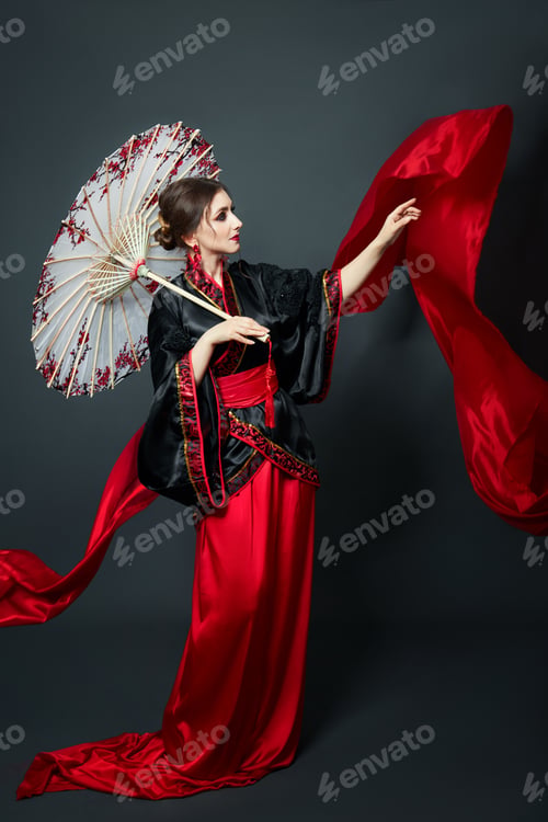 Preview: Woman Is Dressed In Red Chinese Japanese Folk Clothing. Flying Fabric, Beautiful Umbrella And Fan