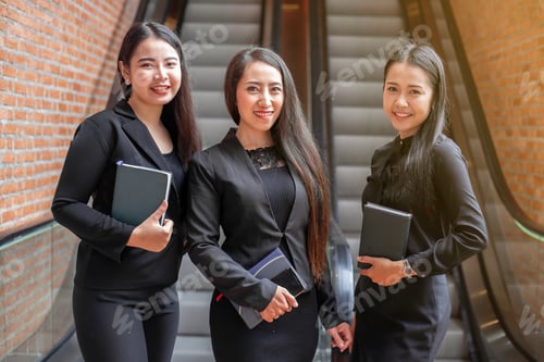 Preview: The Asian Women Wearing The Black Uniform Standing In The Front Of Escalator With Brick Wall