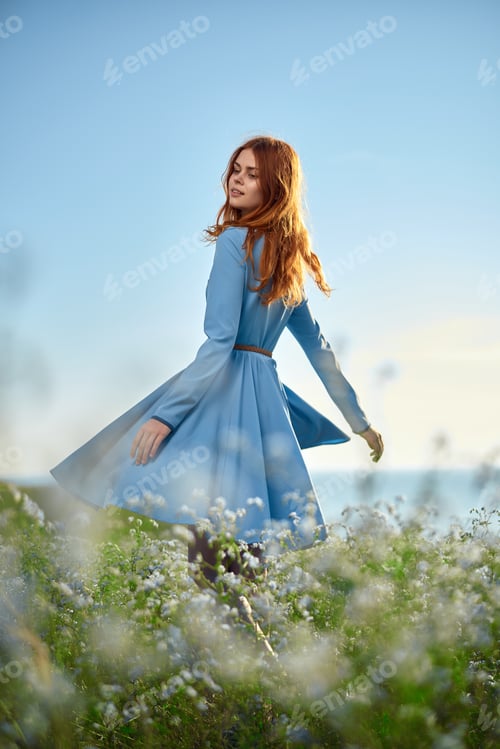 Preview: Woman At Sunset In A Blue Dress In A Field Of Chamomile