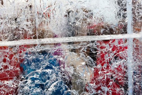 Preview: Glacial Transparent Wall Of Ice With Interesting Drawings And Patterns And Colorful Objects Behind.