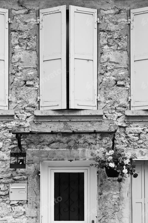 Preview: Facade Of A Building In France Is Decorated With Fresh Flowers, A Birdcage And Closed Windows In
