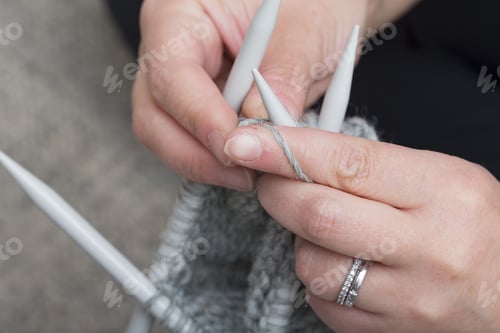 Preview: Hands Knitting Gray Yarn with Needles