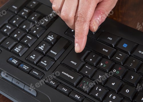 Preview: A Woman Is Pushing The Enter Button On A Black Keyboard.