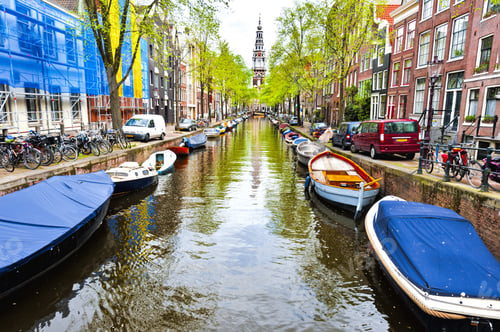 Preview: Urban Scene In Amsterdam With Boats And Many Bicycles. Street View With Bikes Parked On An