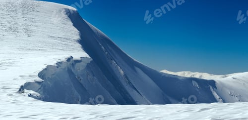 Preview: Winter Mountains Ridge With Overhang Snow Caps And Snowboard Tracks On Blue Sky Background