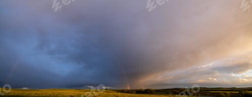 Preview: Cloudy After Rain Sunset Sky With Colorful Rainbow Above Spring Rapeseed And Small Farmlands Fields