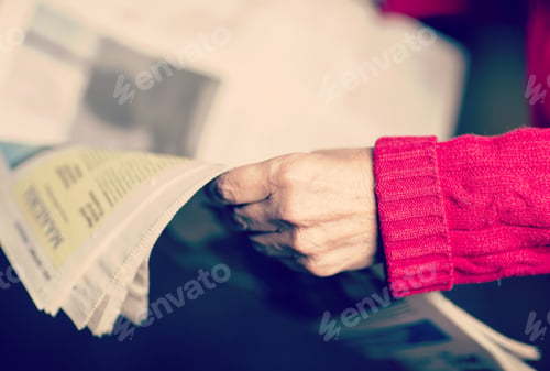 Preview: An Elderly Woman Is Reading A Newspaper. Image Has A Vintage Effect.