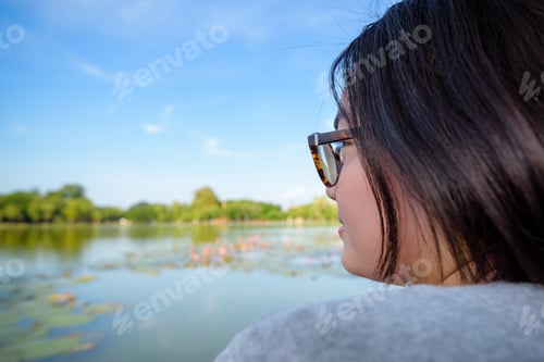 Preview: Side Face Of A Woman Wearing Eyeglasses Sitting Relax And Looking At A Natural Landscape Near The