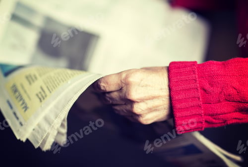 Preview: An Elderly Woman Is Reading A Newspaper. Image Has A Vintage Effect.
