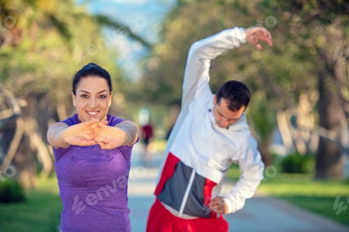 Preview: Young Jogging Couple Warming Up And Stretching Before Morning Running In The City