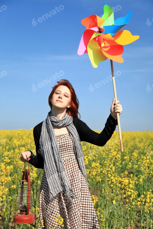 Preview: Young Girl With Wind Turbine At Rapeseed Field.