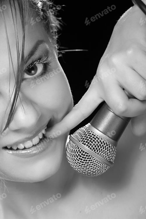 Preview: Portrait Of A Young Singer With A Microphone On A Black Background
