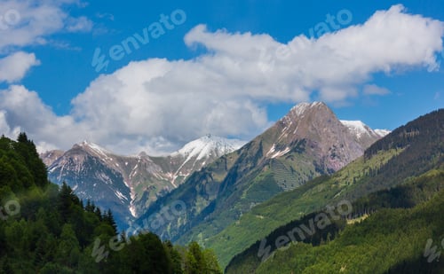 Preview: Summer Alps Mountain Landscape With Fir Forest On Slope And Snow Covered Rocky Tops In Far, Austria.