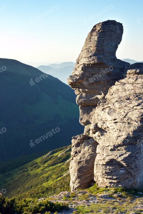 Preview: Big Stony Figure In Human Face Form On Evening Mountain Ridge