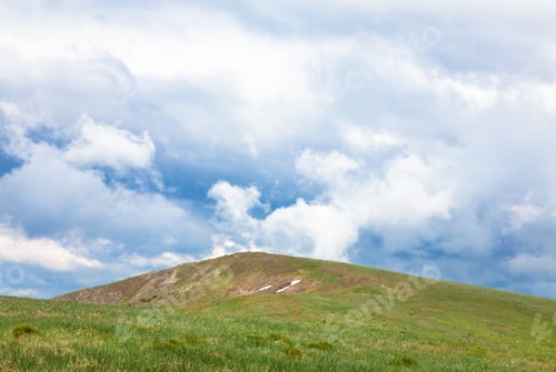 Preview: Green Grass Covered Summer Mountain Top And Overcast Cloudy Sky