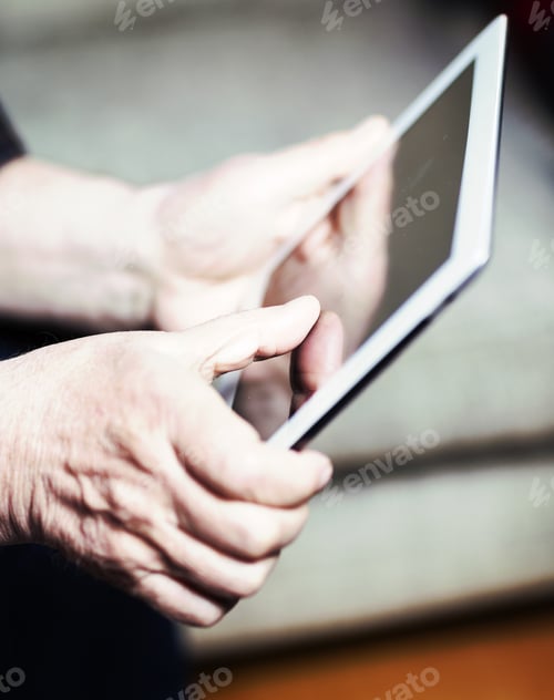 Preview: An Elderly Man Browsing The Internet With A Tablet In A Living Room And Sitting In A Sofa. Image