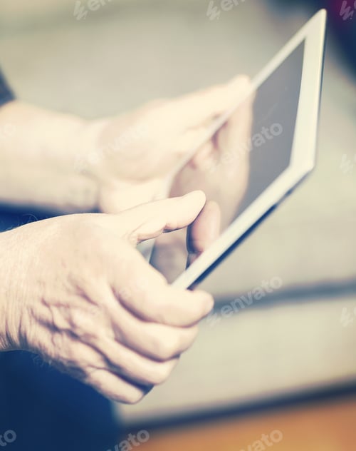 Preview: An Elderly Man Browsing The Internet With A Tablet In A Living Room And Sitting In A Sofa. Image