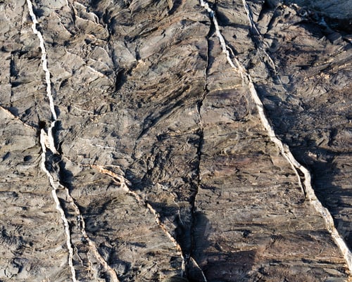 Preview: Part Of Rock Closeup With White Stripes Of Another Geological Material. Nature Background.