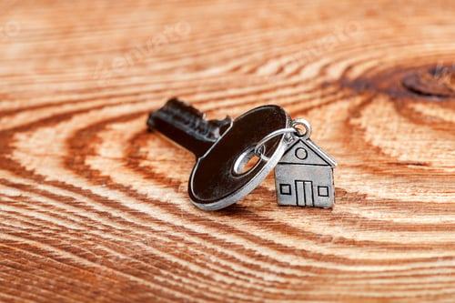 Preview: Door Key On A Table, A Table From A Retro Of A Board And In The Foreground A Charm In The Form Of A