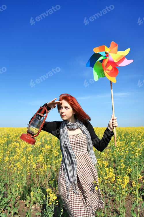 Preview: Young Girl With Wind Turbine At Rapeseed Field.