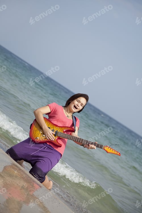 Preview: Young Brunet Girl With Guitar On The Beach.