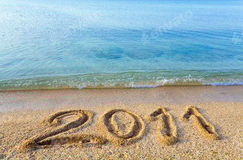 Visualização: Inscrição de 2011 na praia arenosa e na superfície da água do mar Morning Sheen