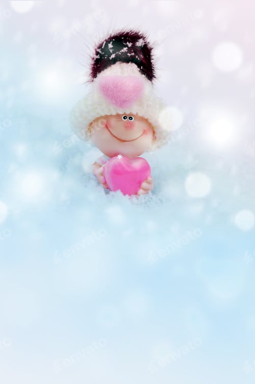 Preview: Valentine Toy In Knitted Hat With Heart Against A Background Of Snow.The Metaphor Of Love. Greeting