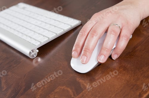 Preview: A Woman Is Using A Wireless White Keyboard And Mouse. The Woman Is Caucasian And She Is Using The