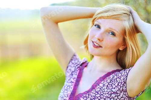 Preview: Smiling Woman Relaxing in a Lush Green Meadow