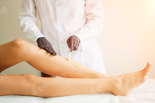 Preview: Close Up Beautician Waxing Female Legs In Spa Center