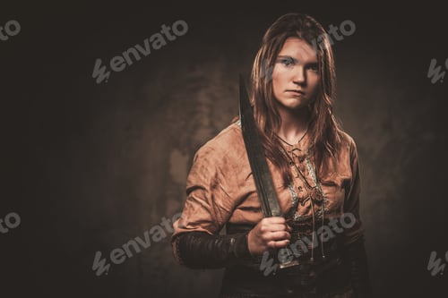 Preview: Serious Viking With Sword In A Traditional Warrior Clothes, Posing On A Dark Background.