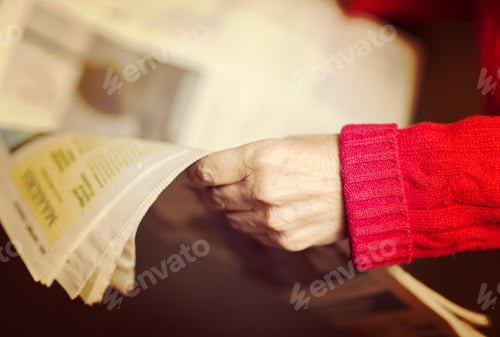 Preview: An Elderly Woman Is Reading A Newspaper. Image Has A Vintage Effect.