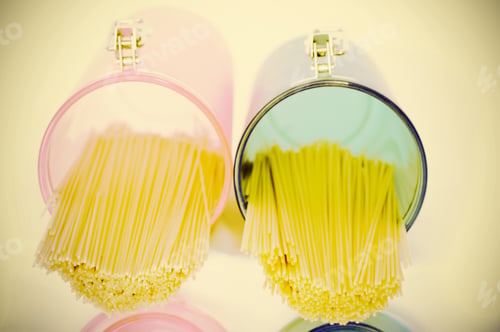 Preview: Pasta In Pink And Blue Glass Jar On A White Background. Retro Style